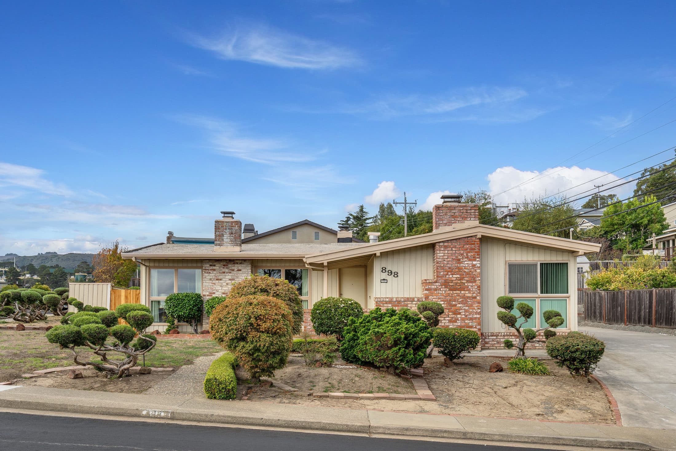 898 Lomita Avenue. The front of the house behind its sculpted garden.