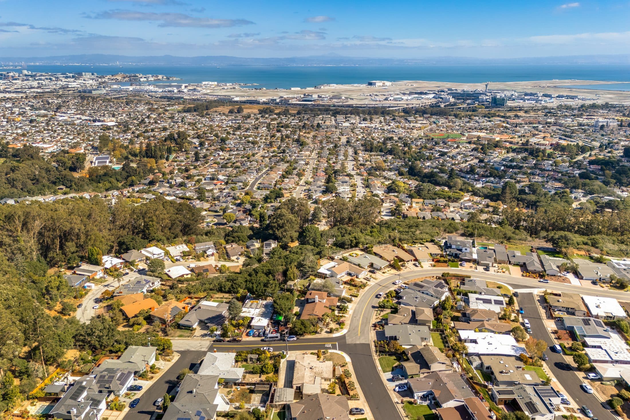 The neighborhood around 898 Lomita Avenue from the air, with the bay beyond.