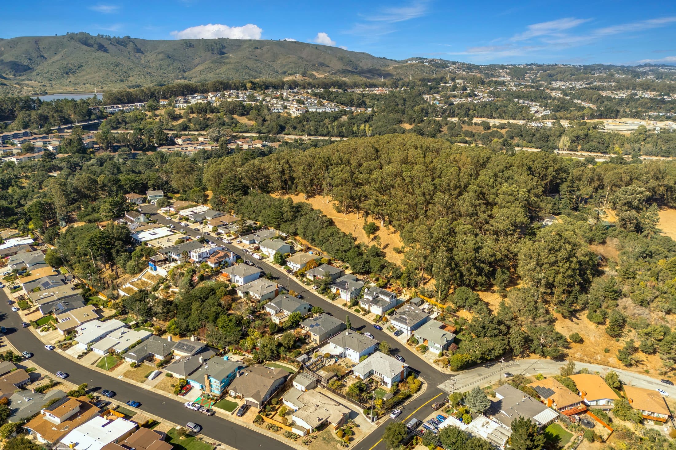 The neighborhood around 898 Lomita Avenue from the air, with the hills behind.