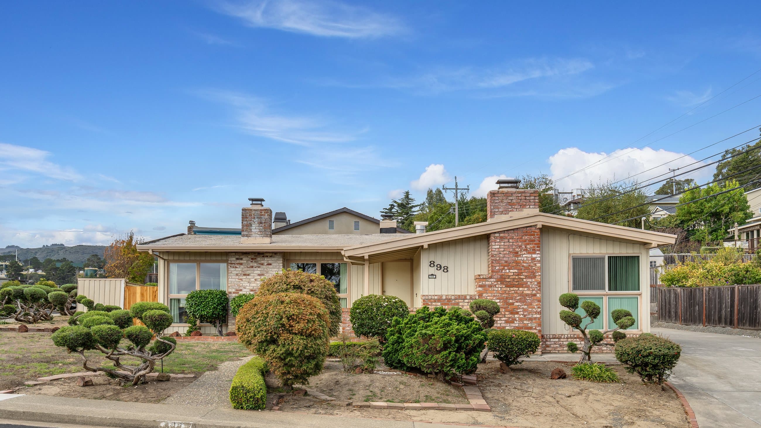 898 Lomita Avenue, the front of the house behind its sculpted garden.
